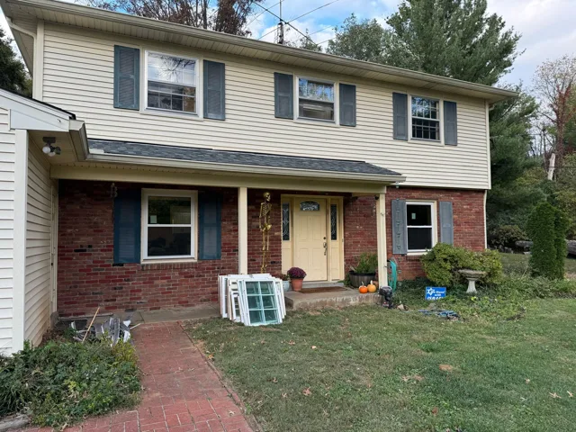 Two-story home with windows and a front lawn