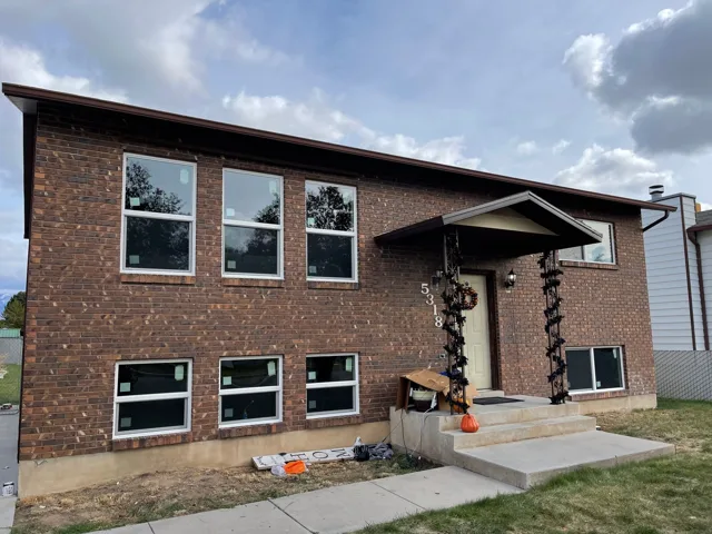 Brick house with new windows and covered entryway.