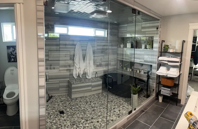 Bathroom with glass shower, pebble floor, and towel rack; toilet visible on the left.